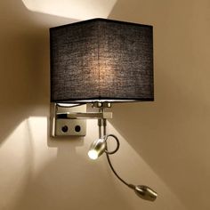 a lamp that is on the side of a wall with a light attached to it