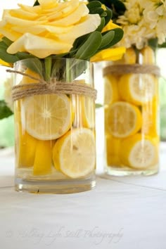 two vases filled with lemon slices and flowers