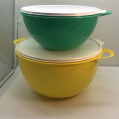 two yellow and green bowls stacked on top of each other