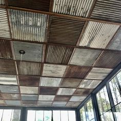 an old tin ceiling in a room with large windows and lots of wood planks