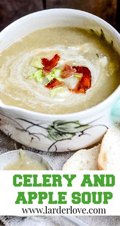 a close up of a bowl of soup on a table with bread in the background