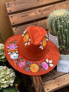 This Mexican Suede Hat is perfect to add that special touch to any outfit. This Mexican Hat is completely hand painted and one of a kind! This structured suede hat has a high crown and a teardrop top. The wide brim is accented by a band and colorful painted flowers. The hat is made in Mexico by artisanal hands made with love for you to look gorgeous and fashionable. Artisan Red Festival Hat, Artisan Red Hats For Festival, Artisan Red Hat For Festivals, Artistic Hand Painted Hat With Curved Brim, Artistic Hand Painted Flat Brim Hat, Artisan Hand Painted Wide Brim Fedora, Bohemian Wide Brim Hand Painted Hat, Bohemian Hand Painted Hats With Short Brim, Bohemian Flat Brim Hand Painted Hat