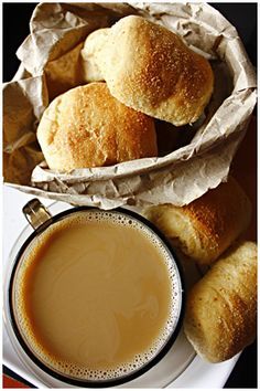 some rolls and a cup of coffee on a table