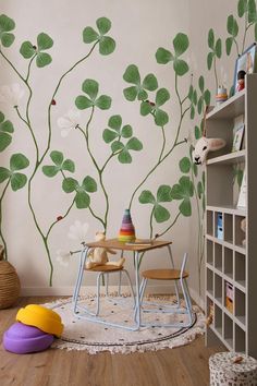 a child's room with a table and chairs in front of a wall mural