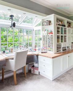 a large white desk sitting in the middle of a room with lots of windows on it