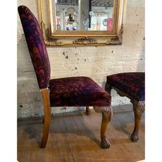 an ornately decorated chair sits in front of a mirror