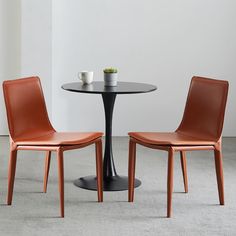 two chairs sitting at a table with a bowl of fruit on top of the table