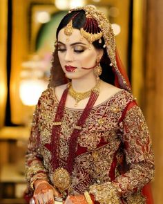 a woman in a red and gold bridal outfit