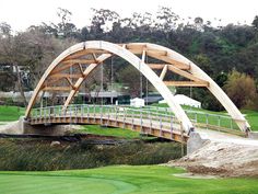 a wooden bridge over a green golf course