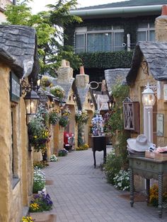 an alley way with lots of houses and flowers on the sides, including a piano