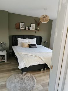 a bedroom with a bed, nightstands and pictures on the wall