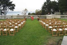 rows of wooden chairs sitting on top of a lush green field