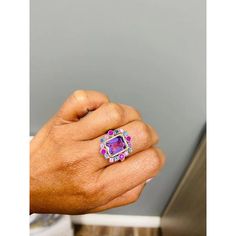 This ring has a bright and vivid purple Emerald Cut Amethyst that weighs 2.61 Carats and is embellished with 16 Multicolor Sapphires that weigh 1.13 Carats as well as 34 Round Cut Diamonds that weigh 0.17 Carats (clarity: SI1-F). The total carat weight of the ring is 3.91 Carats. The ring is crafted in 14 Karat Yellow Gold and weighs approximately 6.6 Grams.  The ring is a size 7  Exact dimensions for this item are unknown. Please reach out in the seller Q&A for any questions on measurements. Luxury Purple Gemstones With Halo Setting, Luxury Purple Amethyst Ring With Halo Setting, Luxury Purple Amethyst Birthstone Ring, Luxury Multi-stone Purple Jewelry, Luxury Purple Multi-stone Jewelry, Luxury Purple Sapphire Ring With Diamond, Luxury Purple Multi-stone Sapphire Ring, Luxury Multicolor Amethyst Ring With Gemstone Accents, Formal Purple Sapphire Ring With Gemstone Accents