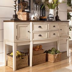 a white dresser with baskets and flowers on it's top shelf next to other items