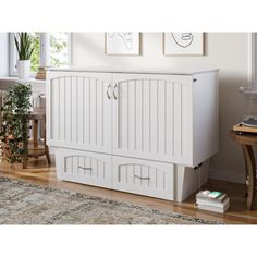 a white cabinet sitting on top of a wooden floor