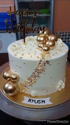 a white and gold birthday cake on a table