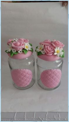 two glass jars with pink and white flowers in them