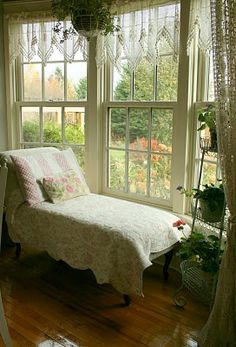 a white day bed sitting next to a window