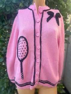 Here is a rare vintage 1970s Pink tennis sweater. It has been hand made.Pink color with black knit. Buttons up the front.Bust 38", from top of a shoulder to bottom 25" length This is a one of a kind.So cute !! In nice vintage condition Black Vintage Sweater For Spring, Vintage Black Sweater For Spring, Retro Pink Sweater For Fall, Vintage Pink Sweater For Fall, Vintage Pink Cardigan For Spring, Vintage Pink Sweater For Spring, Barbiecore Sweater, Pink Fitted Crew Neck Cardigan, Spring Vintage Pink Sweater