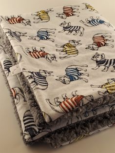 two blankets are folded on top of each other, with cartoon characters all over them