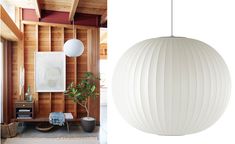 a white lamp hanging from the ceiling next to a room with wooden paneled walls