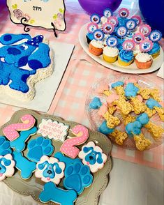 there are some cookies and cupcakes on the table