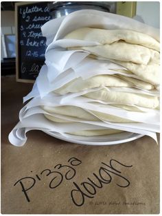 a pile of uncooked bread sitting on top of a table next to a sign