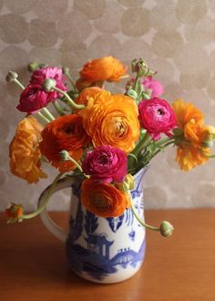 a blue and white vase filled with colorful flowers