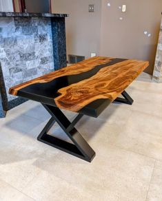 a wooden table sitting on top of a tile floor next to a fireplace in a living room