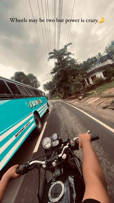 a person riding a motorcycle down a street next to a bus