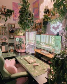 a computer desk with two monitors, keyboard and mouse in front of some potted plants