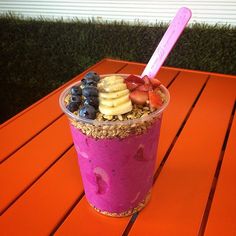 a smoothie topped with bananas, blueberries and strawberries on top of it