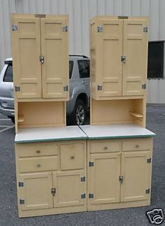 two tan cabinets sitting in the middle of a parking lot next to a silver truck