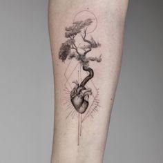 a tattoo on the leg of a person with a tree and heart