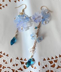 blue Sakura Flower Earrings The blue sakura flower earrings feature three glazed sakura and one crystal drop. They are really comfortable for everyday wear.  Available in GOLD and Silver finish! M A T E R I A L S * A N D * S I Z E  The hook is 14K gold filled - Length: 80mm(without the hook) - Width: 23mm Whimsical Blue Drop Earrings, Whimsical Blue Jewelry With Flower Charm, Bohemian Light Blue Flower Jewelry, Blue Whimsical Dangle Flower Earrings, Whimsical Blue Dangle Flower Earrings, Blue Dangle Earrings For Spring, Light Blue Flower Jewelry For Spring, Delicate Blue Flower-shaped Earrings, Delicate Blue Flower Shaped Earrings