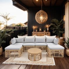 an outdoor living area with wicker furniture and potted plants