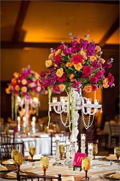 the centerpieces are adorned with crystal candlesticks and colorful flowers in tall vases