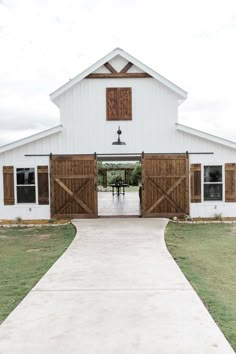 a white barn with wooden doors and windows