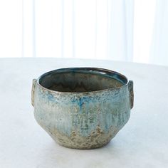 a blue bowl sitting on top of a white table