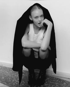 a black and white photo of a woman sitting on the ground