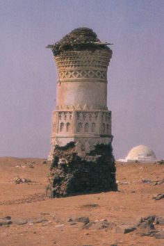 an old tower sitting in the middle of a desert area with no people around it