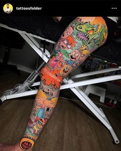 a person with tattoos on their legs sitting in a chair