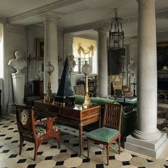 a living room filled with lots of furniture and decor on top of checkered flooring