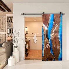 an open door to a living room with blue and brown artwork on the wall behind it