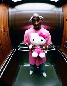 a man holding a hello kitty stuffed animal in his arms while standing next to an escalator