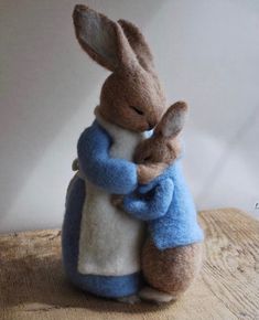 two stuffed animals hugging each other on a table