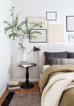 a bed room with a neatly made bed and pictures on the wall