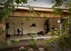 an open garage with lots of plants and tools in the back ground, surrounded by greenery