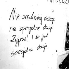 graffiti written on the side of a white wall with writing in black and white colors