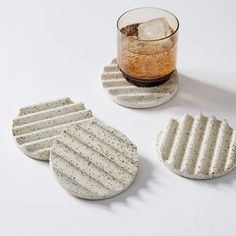 three coasters and a glass on a white surface